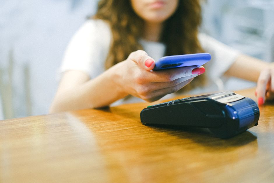 スマートフォンにかざしてクレジットカードで決済する手元の様子