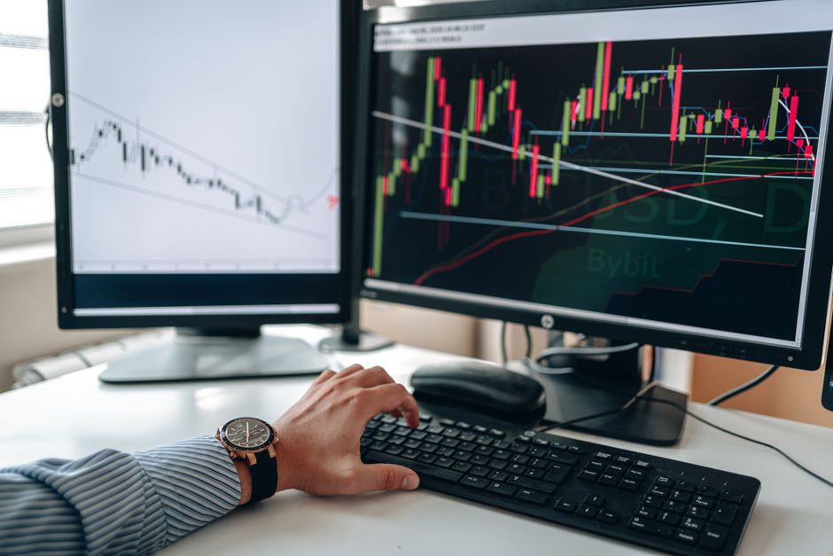 ノートパソコンで株価チャートを確認するトレーダー